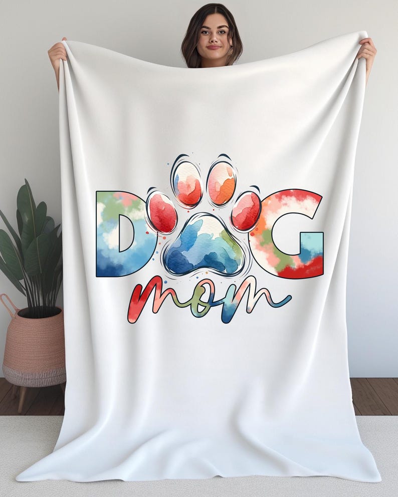 May include: White fleece blanket with a colorful watercolor paw print and the text "Dog Mom".