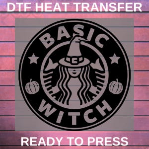 May include: Black and gray DTF heat transfer design with the text "BASIC WITCH" in a circular logo. The design features a witch with a hat, two pumpkins, and two stars. The text "READY TO PRESS" is at the bottom.