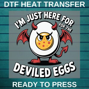 May include: DTF heat transfer design featuring a cartoon deviled egg with devil horns, wings, and a tail. The text reads "I'M JUST HERE FOR THE DEVILED EGGS" and "READY TO PRESS". The egg has a yellow yolk with red spots and an angry expression.