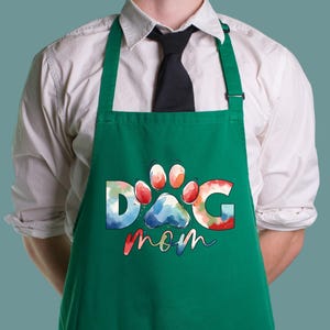 May include: Green apron with a watercolor design of a paw print and the text "Dog Mom".
