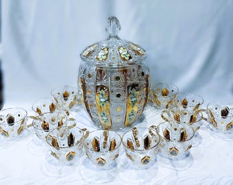 May include: A clear crystal punch bowl set with a matching lid and twelve cups. The set features gold and floral accents. The punch bowl is approximately 12 inches tall.