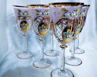May include: Set of six clear glass wine glasses with gold trim and pink and white floral designs.