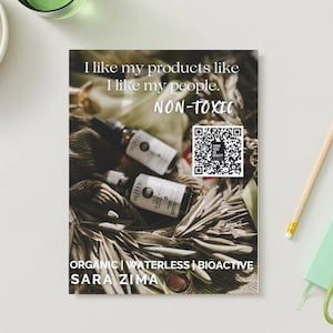 Peut inclure: Une image de produit avec un texte superposé qui dit "J'aime mes produits comme j'aime mes gens. NON-TOXIQUE". L'image montre trois flacons en verre avec une étiquette brune qui dit "OLIVED". Les flacons sont posés sur un lit de feuilles séchées. L'image comprend également un code QR. Le texte en bas de l'image dit "ORGANIQUE | SANS EAU | BIOACTIF SARA ZIMA".