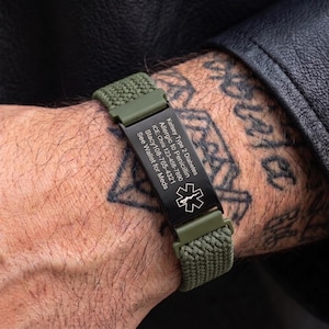 May include: An olive green woven medical alert bracelet featuring a black rectangular metal plate engraved with the text: Kelsey Type 2 Diabetes, Allergic to Penicillin, ICE: Chris 123-456-7890, Stacy 108-765-4321, See Wallet for Meds, and a medical star symbol.