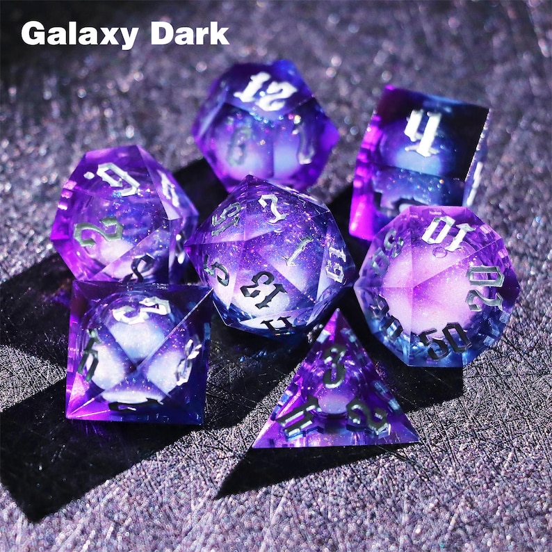 May include: Set of seven polyhedral dice with a galaxy design. The dice are purple with white numbering and a swirling, starry interior. The text "Galaxy Dark" is at the top of the image. Ideal for tabletop games.