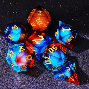May include: A set of seven polyhedral dice in various shapes, including a d20, d12, d10, d8, d6, and d4. The dice are a mix of blue and red with gold numbering. The dice are designed for tabletop role-playing games.