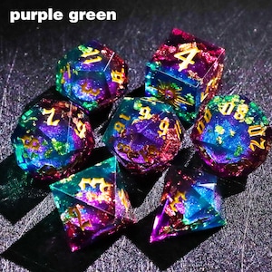 May include: Set of seven polyhedral dice in vibrant purple, green, and blue hues. Each die features gold-colored numbers. The dice are made of a translucent material, with a glittery, galaxy-like effect. The text "purple green" is in the top left corner.