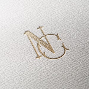 Puede incluir: Un monograma dorado en relieve que presenta las letras N y C entrelazadas en una tipografía decorativa con remates. El diseño está impreso en una superficie de papel blanco texturizado, creando un sutil efecto tridimensional.