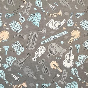May include: Gray fabric with a repeating pattern of musical instruments in white, light blue, and tan. Guitars, trumpets, drums, and other instruments are featured. Geometric shapes and stars fill the spaces between the instruments.