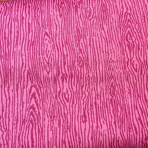 K&ouml;nnte beinhalten: Nahaufnahme eines pinkfarbenen Stoffes mit Holzmaserung. Das Design zeigt vertikale Linien in verschiedenen Rosat&ouml;nen, die einen strukturierten, nat&uuml;rlichen Eindruck erzeugen. Die Farbpalette des Stoffes wird von Rosat&ouml;nen dominiert.