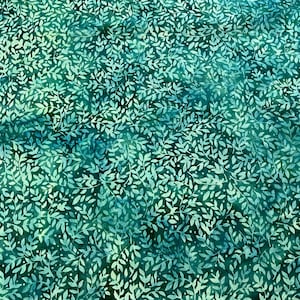 May include: A fabric with a repeating pattern of white leaves on a teal and dark green background. The leaves have a delicate, detailed appearance, and the background has a mottled, watercolor-like effect.