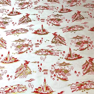 May include: White fabric with a repeating pattern of red and gold illustrations. The design features stylized mountains, buildings, trees, and other landscape elements. The overall aesthetic is reminiscent of a vintage map or travel-themed design.