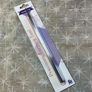 May include: A precision turning tool in a clear plastic package. The package has a white background with red and purple text that reads "Precision Turning Tool". The tool is silver and has a pointed tip.