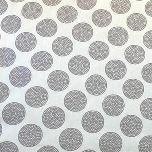 Może przedstawiać: Biała tkanina z powtarzającym się wzorem dużych, szarych kół. Każde koło wypełnione jest teksturowanym, kropkowanym wzorem. Odpowiednia do różnych projektów rzemieślniczych i krawieckich.