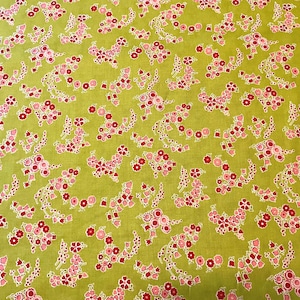 May include: Close-up of a fabric featuring a repeating floral pattern. The fabric has a light green background with clusters of pink and red flowers. The flowers are outlined in white, creating a detailed design. Suitable for sewing projects, this fabric is ideal for crafts.