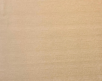 May include: Close-up of a textured, beige fabric. The surface has a subtle, woven pattern, creating a neutral backdrop. The color is a warm, light tan, suitable for various craft projects or home decor.