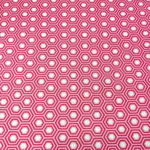 Pode incluir: Close-up de um tecido com um padrão geométrico repetitivo. O design apresenta hexágonos brancos rodeados por um contorno rosa vibrante, sobre um fundo rosa mais claro. O tecido tem um padrão consistente e geral.