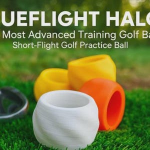 May include: The image displays several golf training balls in various colors, including white, yellow, and orange, resting on green grass. The text "TRUEFLIGHT HALO" is at the top, with additional text below. These are short-flight golf practice balls.