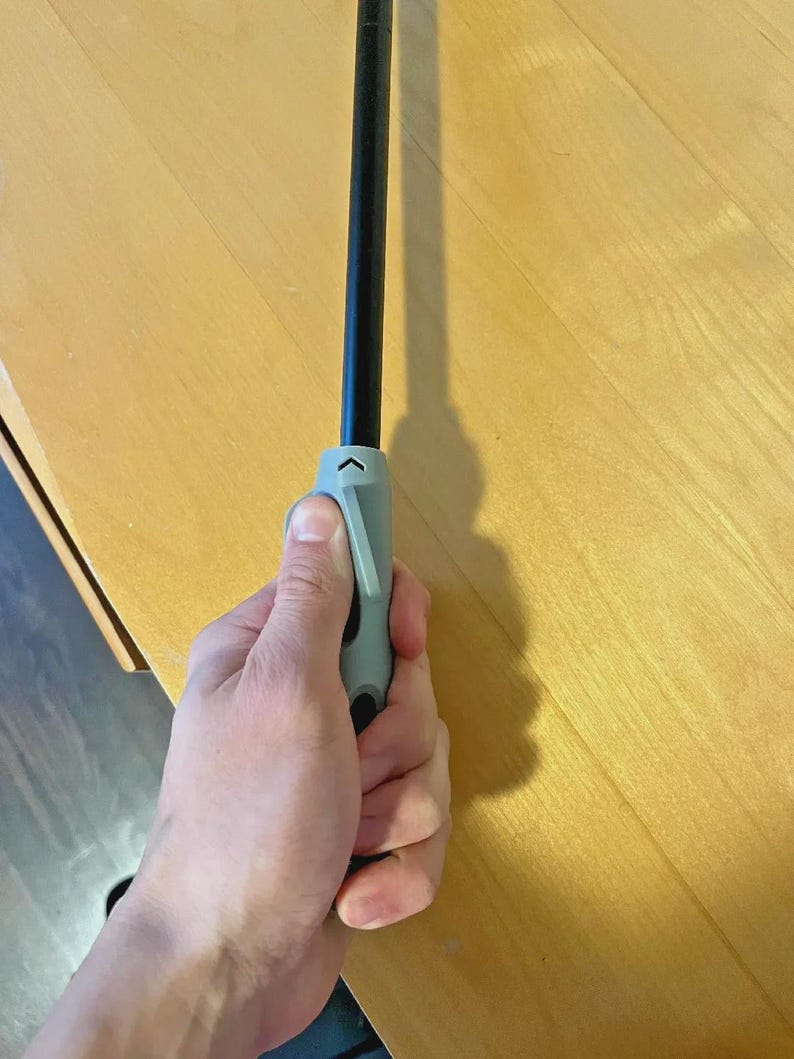 Pu&ograve; includere: Un accendino nero e grigio con un'impugnatura grigia &egrave; tenuto in una mano. L'accendino ha un corpo lungo e sottile e un meccanismo a grilletto sull'impugnatura. L'accendino &egrave; progettato per accendere candele, griglie o altri oggetti.