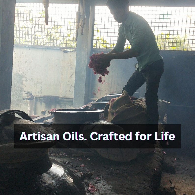 Puede incluir: Una persona trabajando con un gran manojo de flores rosas, probablemente rosas, en un taller. La imagen incluye el texto "Artisan Oils. Crafted for Life."