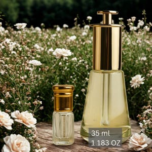 May include: Two glass perfume bottles with gold-colored caps and accents. The larger bottle is filled with a light yellow liquid and has a gold-colored top. The smaller bottle is also filled with a light yellow liquid. The text on the image reads "35 ml 1.183 OZ".