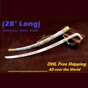May include: A decorative sword with a stainless steel blade, approximately 28 inches long. The sword features a white handle and scabbard with gold-colored accents and ornate designs. The image also includes the text "Stainless Steel Blade".