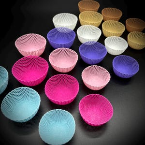 以下が含まれることがあります： ピンク、パープル、ブルー、ホワイトなど、さまざまな色の小さな装飾的なボウルが18個あります。ボウルは織られた素材で作られており、繊細で複雑なデザインが施されています。