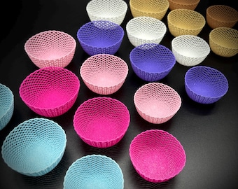 May include: A collection of 18 small, decorative bowls in various colours, including pink, purple, blue, and white. The bowls are made of a woven material and have a delicate, intricate design.