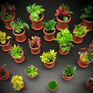 May include: A collection of small, terracotta-colored pots, each containing a different variety of artificial plants. The plants feature vibrant green, yellow, and red foliage, creating a colorful display. The pots are arranged on a dark surface.