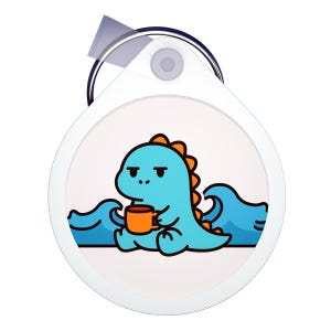 May include: A white, round tag with a cartoon dinosaur illustration. The dinosaur is blue with orange spines, holding an orange mug, and sitting in front of blue waves. The tag has a clear plastic cover and a metal ring.
