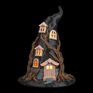 May include: A black witch hat-shaped house with glowing windows and a door. The house is decorated with brown tree branches and has a stone-like base. The windows and door emit a warm, inviting light, creating a whimsical Halloween decoration.