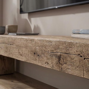 May include: A long, low bench constructed from a single, thick piece of reclaimed light brown wood with a prominent grain, natural knots, and deep surface cracks. The bench features a rectangular block leg on the left side and a textured finish.