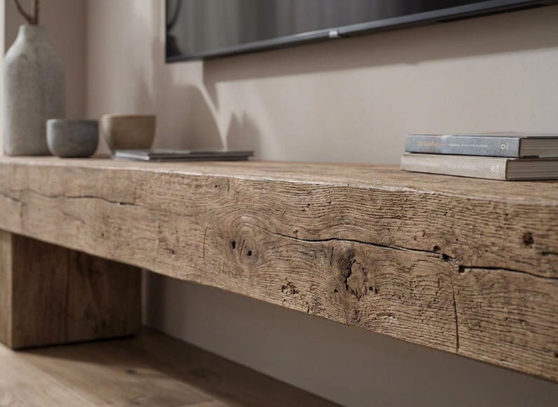May include: A long, low bench constructed from a single, thick piece of reclaimed light brown wood with a prominent grain, natural knots, and deep surface cracks. The bench features a rectangular block leg on the left side and a textured finish.