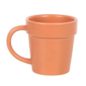 May include: A terracotta-colored ceramic mug with a handle. The mug is designed to resemble a small flower pot, featuring a slightly flared rim and a cylindrical body. The handle is curved and attached to the side of the mug.