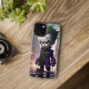 May include: A clear phone case featuring a colourful illustration of the Joker from Batman. The Joker is depicted as a small, cartoonish character wearing a purple and green outfit, with a mischievous grin and white makeup.