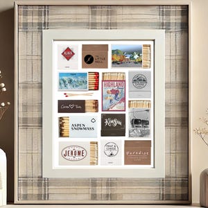 May include: A white frame with a collage of matchbox labels. The labels feature various designs, including mountains, ski resorts, and cityscapes. The labels are arranged in a grid pattern and are surrounded by a white border.