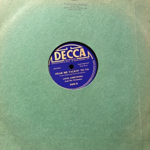May include: Vintage 78 RPM record by Louis Armstrong and His Orchestra, featuring "Hear Me Talkin' To Ya." The record label is blue and gold, set against a pale green record sleeve. The sleeve has the "Recordvelope" logo.