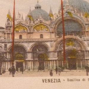 May include: A vintage postcard showing the Basilica di San Marco in Venice, Italy. The postcard features a detailed illustration of the basilica's facade, including its intricate arches, columns, and domes. The text "VENEZIA - Basilica di S. Marco" is printed at the bottom of the postcard.