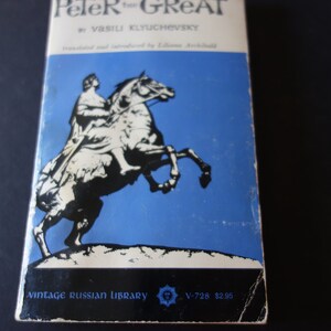 Op de afbeelding: Vintage boekomslag met een zwart-witte illustratie van een man te paard tegen een blauwe achtergrond. De titel van het boek is "Peter de Grote" door Vasili Klyuchevsky. Het boek maakt deel uit van de Vintage Russian Library-serie.