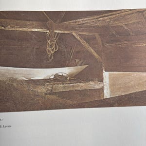 May include: A white wooden boat sits in a wooden shed with a rope hanging from the ceiling. The boat is surrounded by hay and there are wooden beams overhead.