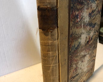 Könnte beinhalten: Ein altes Buch mit braunem Lederrücken und einem gemusterten Einband. Der Rücken hat ein Etikett mit dem Text "History of the United States".