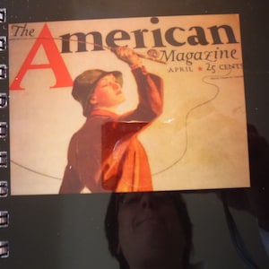 Puede incluir: Una portada de revista vintage con una mujer con un sombrero y una chaqueta marrones, sosteniendo una caña de pescar. La revista se titula "The American Magazine" con la fecha "Abril 25 Cents".