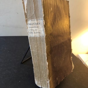 May include: A worn, brown book with the title "Chronique Religieuse" and the text "Tome Second" on the spine.