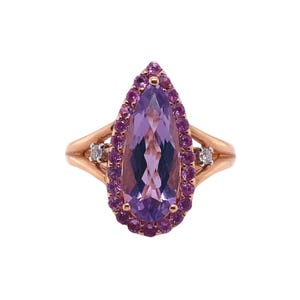 May include: A pear-shaped amethyst ring set in rose gold with a halo of pink sapphires and two small diamonds on the band.