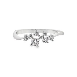 May include: A silver ring featuring a cluster of small, round, clear gemstones. The gemstones are arranged in a floral or starburst pattern across the top of the ring. The band is smooth and curved.