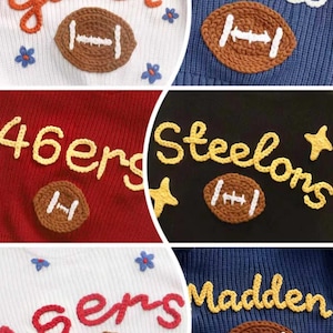 May include: A collection of knit jumpers featuring embroidered names and team-inspired text including Gater, Carlo, 46ers, Steelons, and Madden. Each jumper displays a crocheted brown football applique with white stitching and floral or star accents.