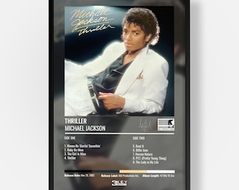 May include: A framed poster featuring the Michael Jackson Thriller album cover art. The image shows the artist in a white blazer and black shirt. Below the image, the text lists the album title, artist name, tracklist, release date, and label.