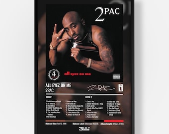 May include: A framed poster featuring the 2Pac All Eyez On Me album cover. The design includes a photograph of 2Pac, the text 2PAC, the album title, a tracklist for Book 1 and Book 2, a signature, and release details including the date Feb 13, 1996.