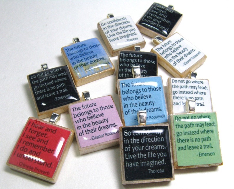 Puede incluir: Una colecci&oacute;n de 10 azulejos cuadrados coloridos con citas inspiradoras y los nombres de autores famosos. Los azulejos est&aacute;n hechos de madera y tienen un acabado brillante. Las citas incluyen: "Ve con confianza en la direcci&oacute;n de tus sue&ntilde;os. Vive la vida que has imaginado." - Thoreau, "El futuro pertenece a aquellos que creen en la belleza de sus sue&ntilde;os." - Eleanor Roosevelt, "No vayas a donde el camino pueda llevar; ve en cambio a donde no hay camino y deja un rastro." - Emerson, "Oigo y olvido. Veo y recuerdo. Hago y entiendo." - Proverbio chino.