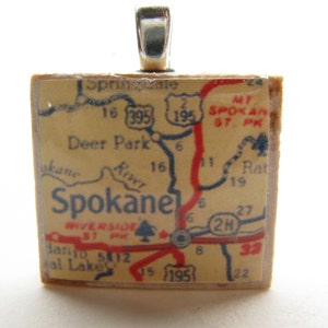 May include: A wooden pendant featuring a vintage map of Spokane, Washington. The map shows roads, highways, and landmarks, including the text "Spokane", "Deer Park", "Riverside", "Mt. Spokane St. Pk", and "2H".